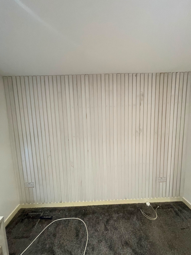 Evenly spaced decorative timber wall panelling fitted across an interior wall