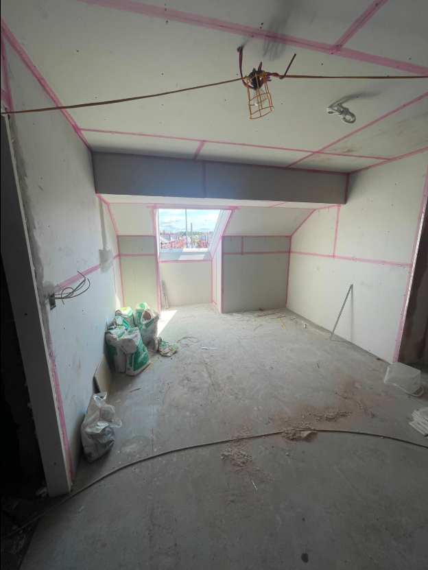 Plasterboard fitted around an interior structural beam and roof window