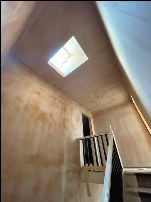 Finished plastered interior surrounding a skylight above a stairwell.