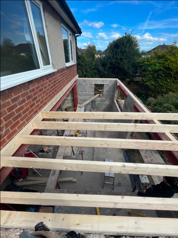 Timber roof joists spanning an extension structure during construction