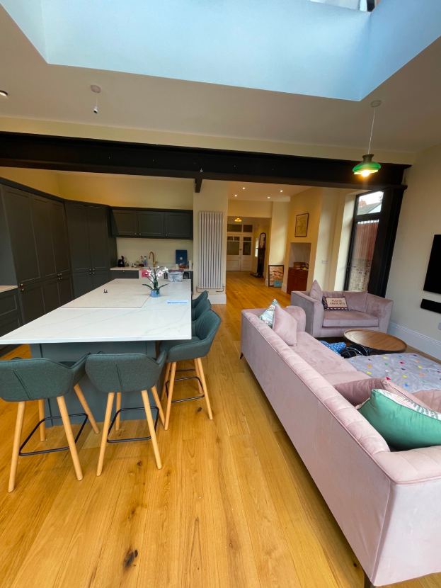 Completed open-plan fitted kitchen and living area beneath a rooflight.