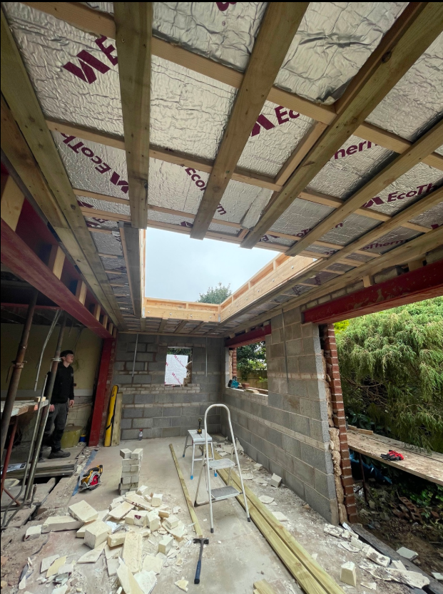 View beneath an insulated timber flat roof with a framed rooflight opening